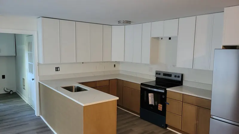 White countertop in an L-shaped kitchen with wood cabinets – Beltway Countertops, Northern Virginia