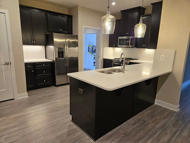 White countertop peninsula with black cabinets and pendant lights – Beltway Countertops, Northern Virginia