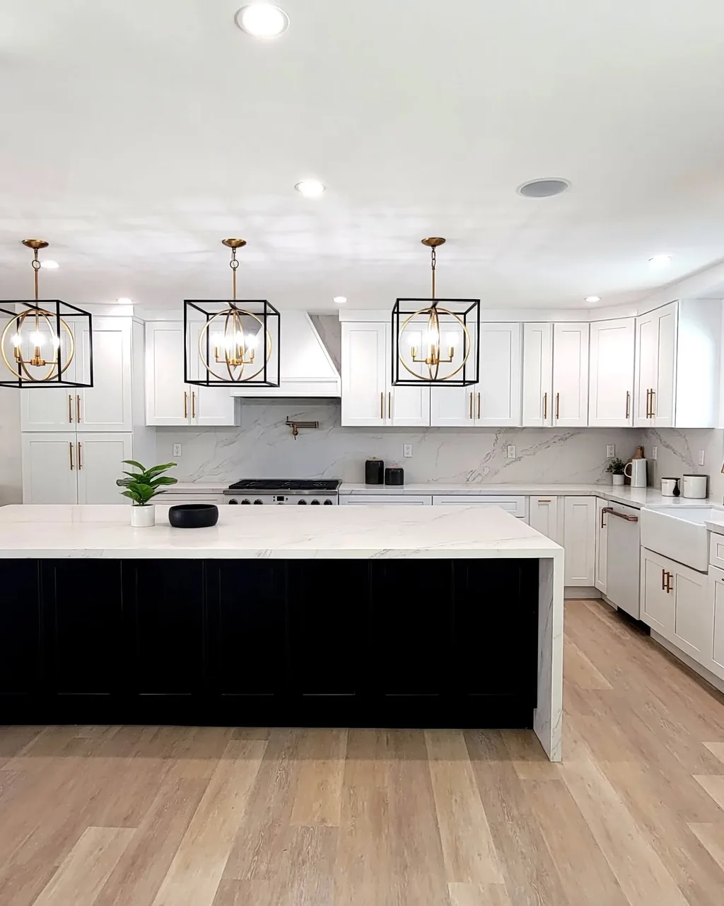 White waterfall kitchen island with black cabinets and a full-height stone backsplash, installed by Beltway Countertops in Sterling, VA